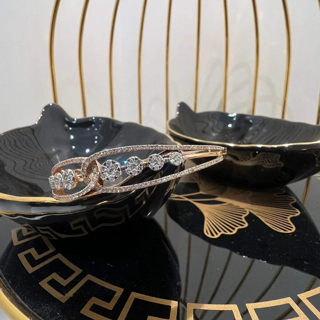 Gold diamond bracelet with round brilliant cut diamonds in chain-link bangle design displayed on luxury background.