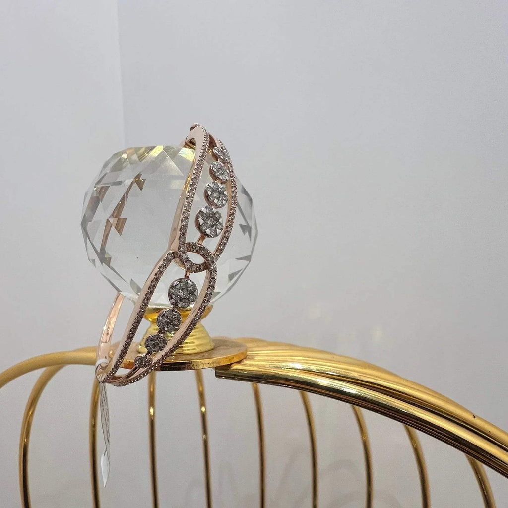 Gold diamond bracelet with round brilliant cut diamonds in chain-link bangle design displayed on luxury background.