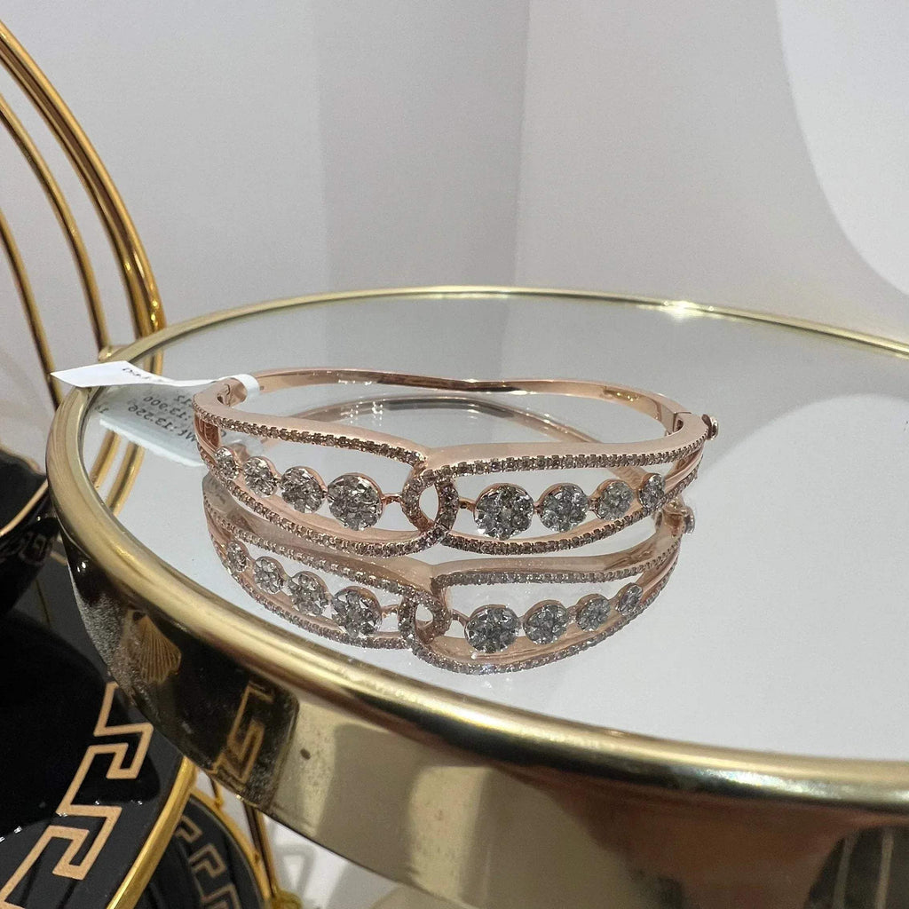 Gold diamond bracelet with round brilliant cut diamonds in chain-link bangle design displayed on luxury background.