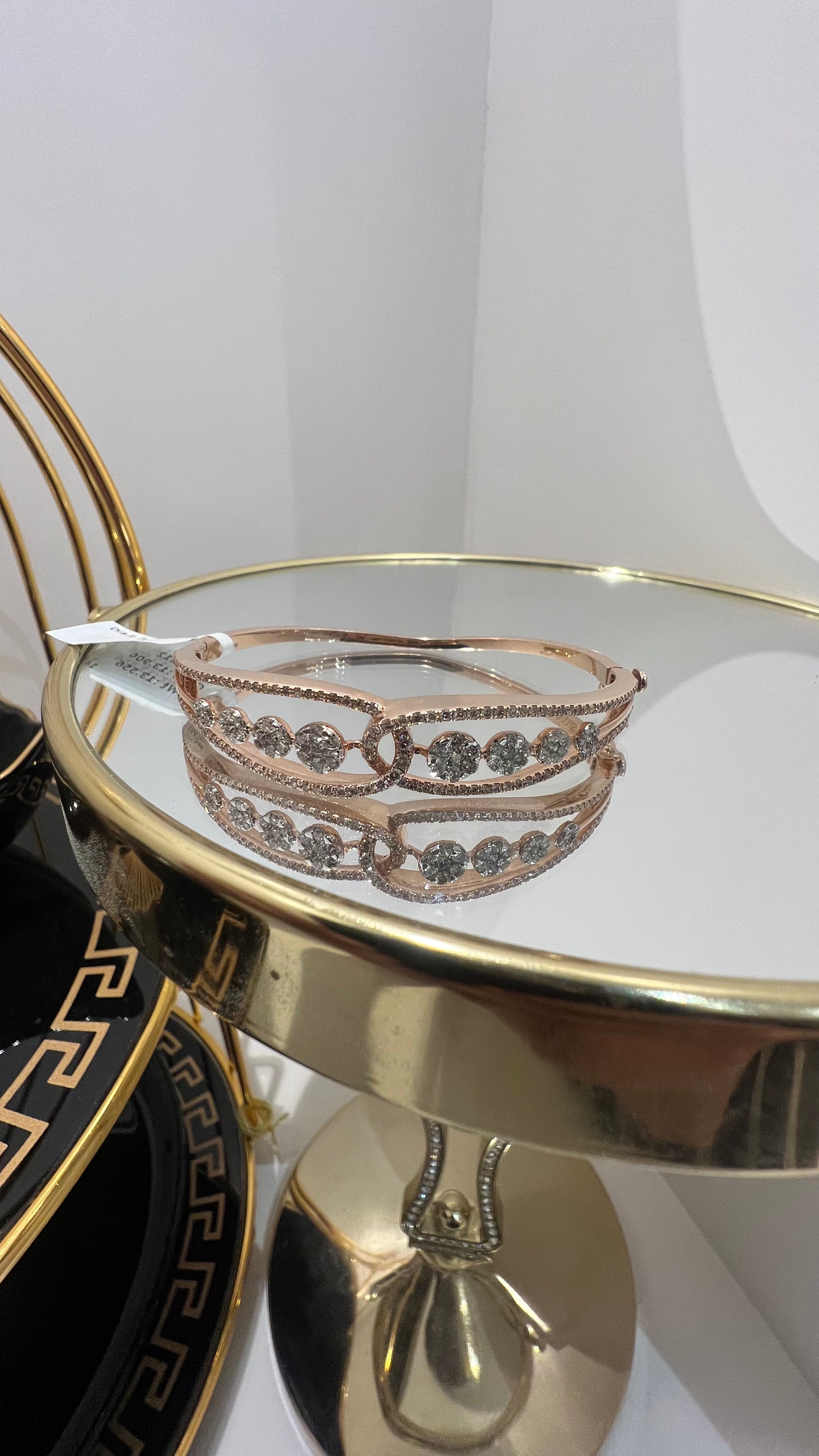 Gold diamond bracelet with round brilliant cut diamonds in chain-link bangle design displayed on luxury background.