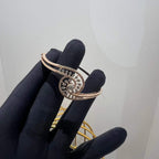 A luxurious gold diamond bracelet with a openable design, featuring a central oval-shaped diamond surrounded by smaller diamonds set in a brilliant cut, displayed on a mannequin hand.