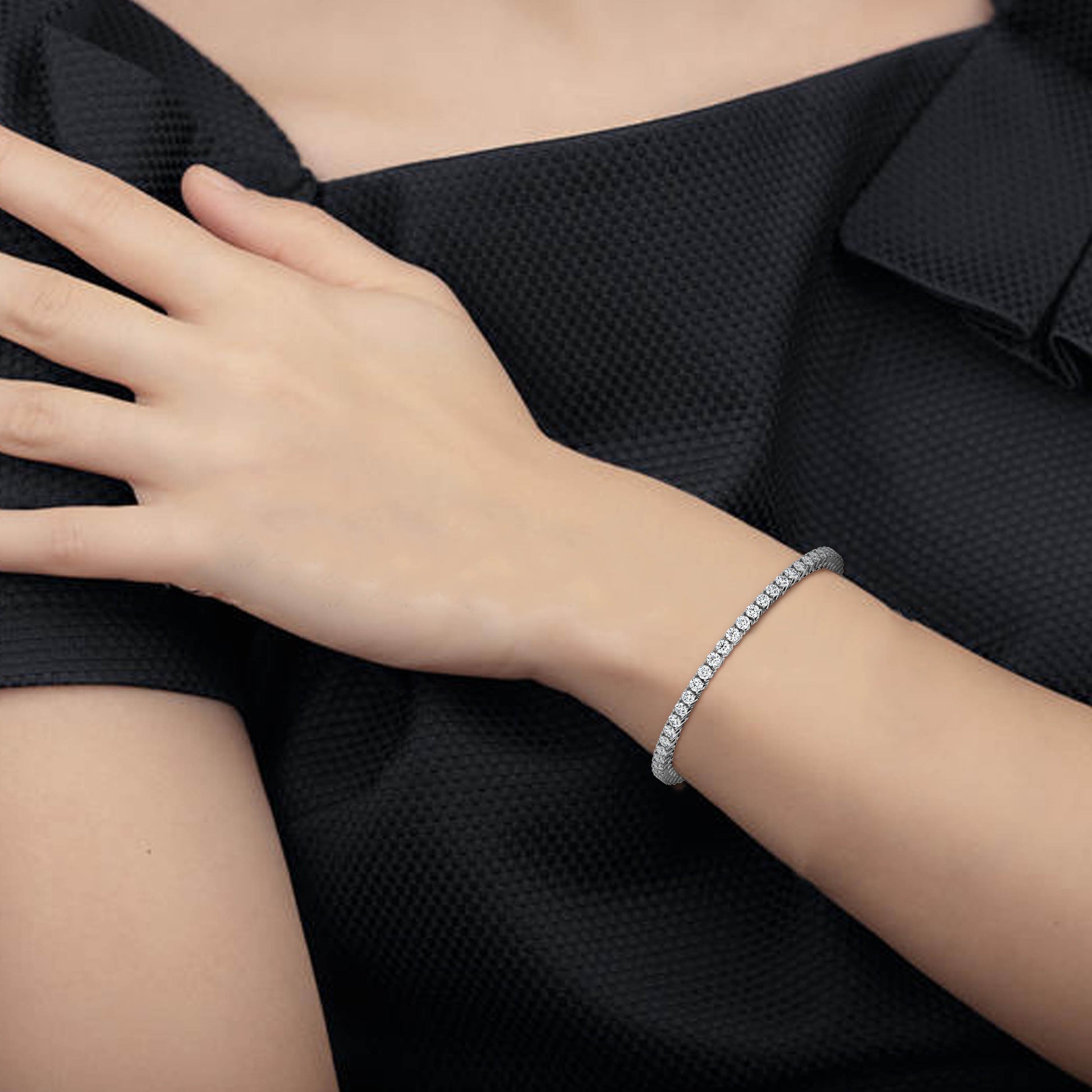 Close-up of a hand wearing a bracelet on a black background