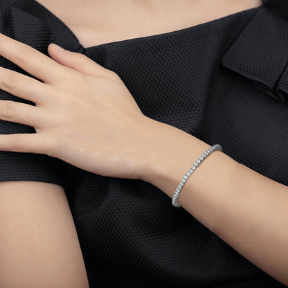 Close-up of a hand wearing a bracelet on a black background
