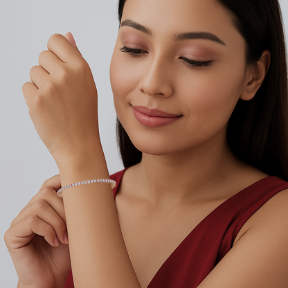 Woman wearing a bracelet, looking at her wrist against a neutral background