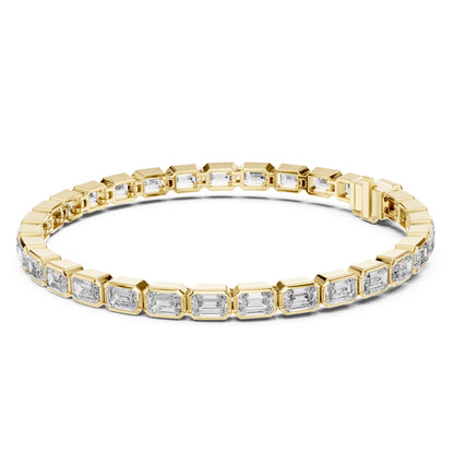 Yellow gold bracelet with emerald cut real diamond accents on a white background