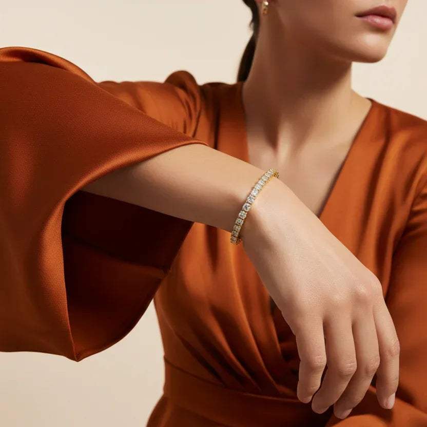 Woman wearing a emerald-cut real diamond tennis bracelet with a neutral background