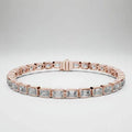 Rose gold bracelet with emerald cut real diamond accents on a white background