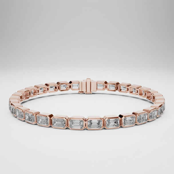 Rose gold bracelet with emerald cut real diamond accents on a white background