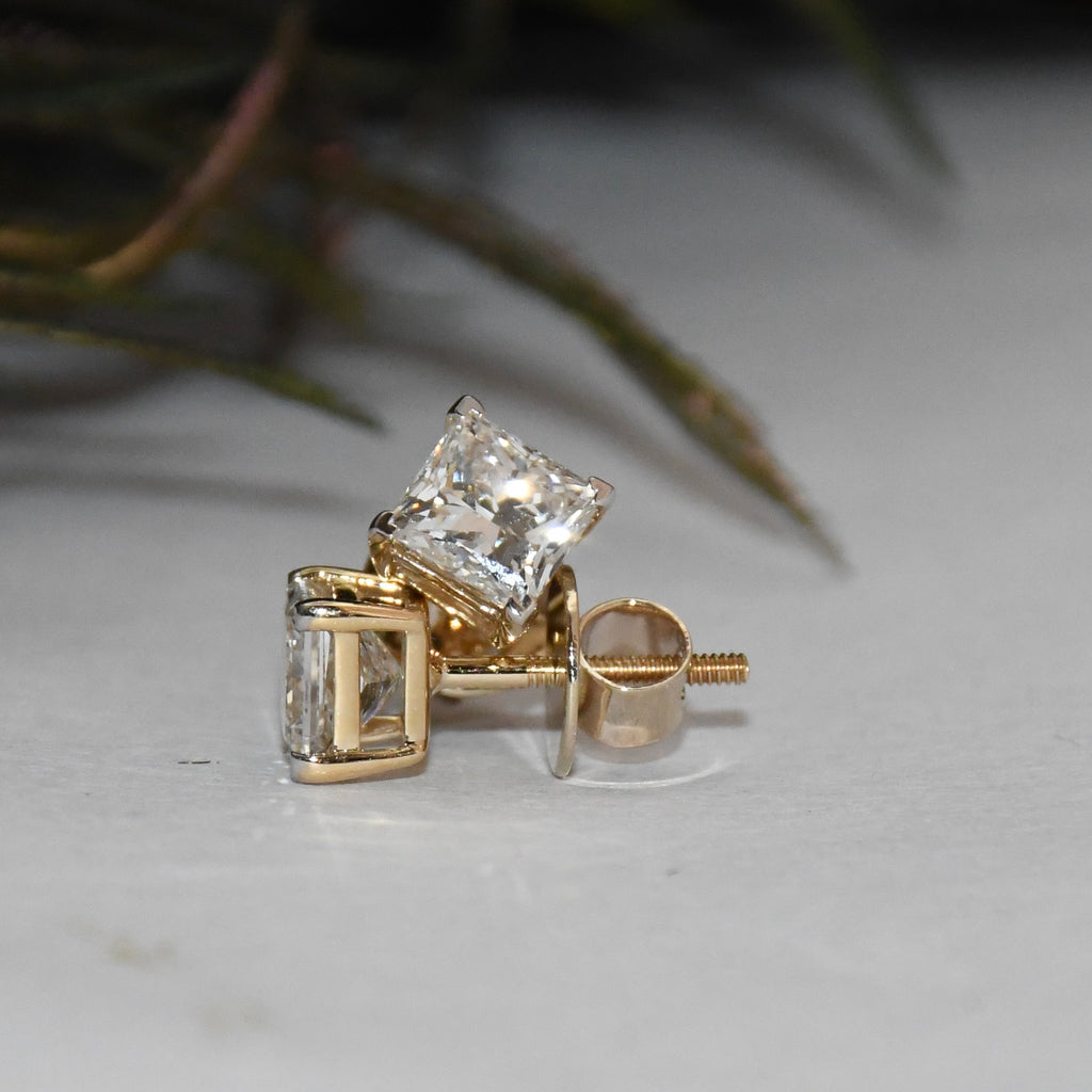 Gold earrings with clear diamonds on a light background