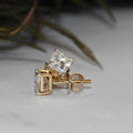 Gold earrings with clear diamonds on a light background