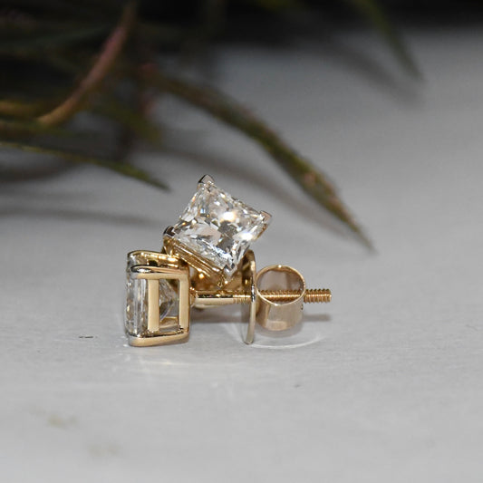 Gold earrings with clear diamonds on a light background