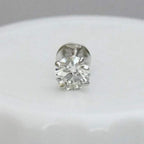 Round solitaire diamond stud earring on a light gray background