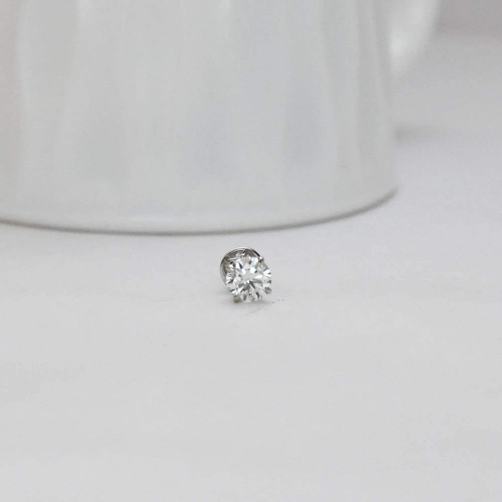 solitaire diamond stud earring on a light gray background