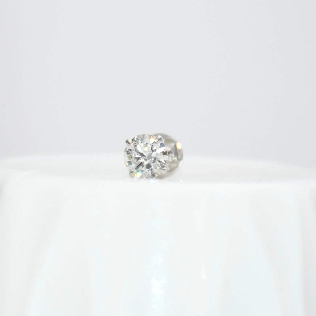 Round solitaire diamond stud earring on a white background