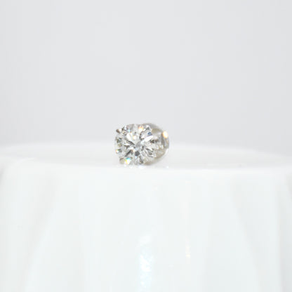 Round solitaire diamond stud earring on a white background