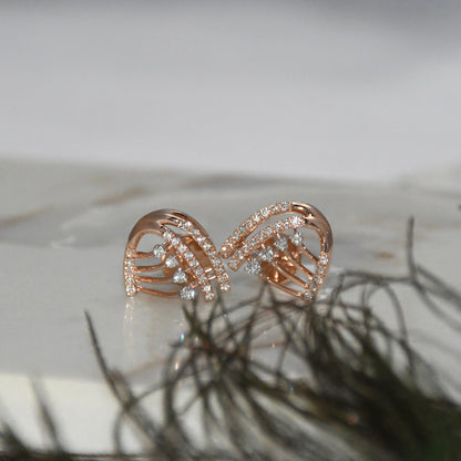 Rose gold bow-shaped earrings with clear diamonds on a light background