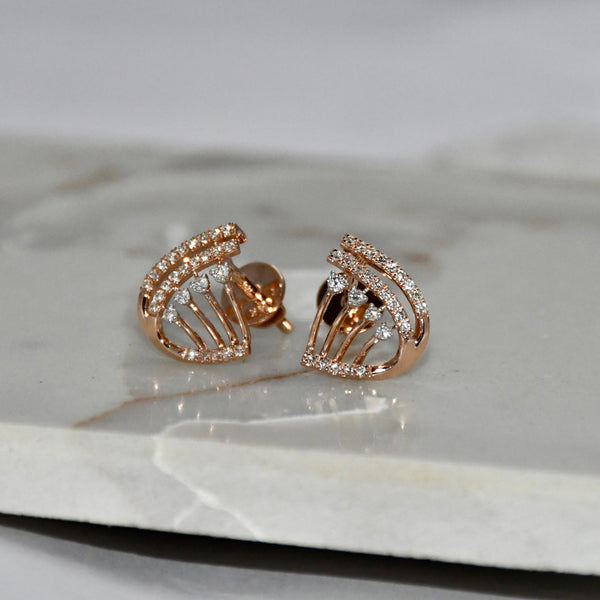 Rose gold earrings with diamond accents on a marble surface