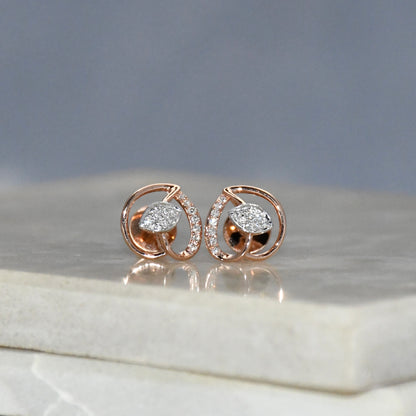 Rose gold earrings with diamonds on a marble surface