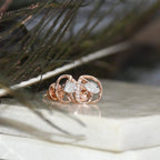 Rose gold earrings with diamond accents on a natural background