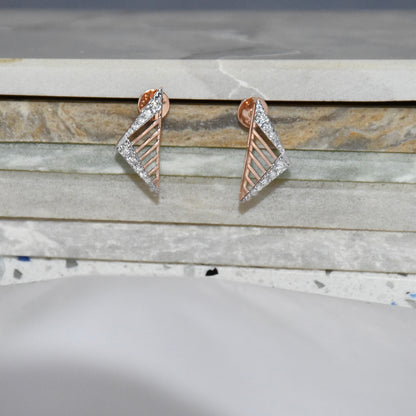 Pair of gold and diamond geometric earrings on a marble surface.