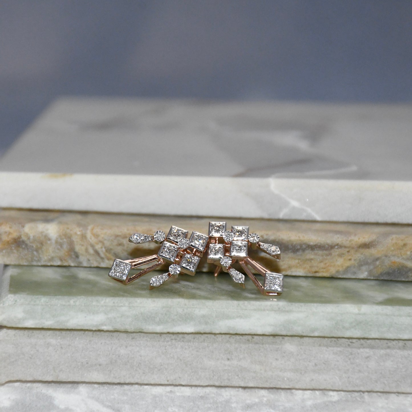 Pair of diamond earrings on a stone surface