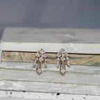 Pair of diamond earrings on a marble surface