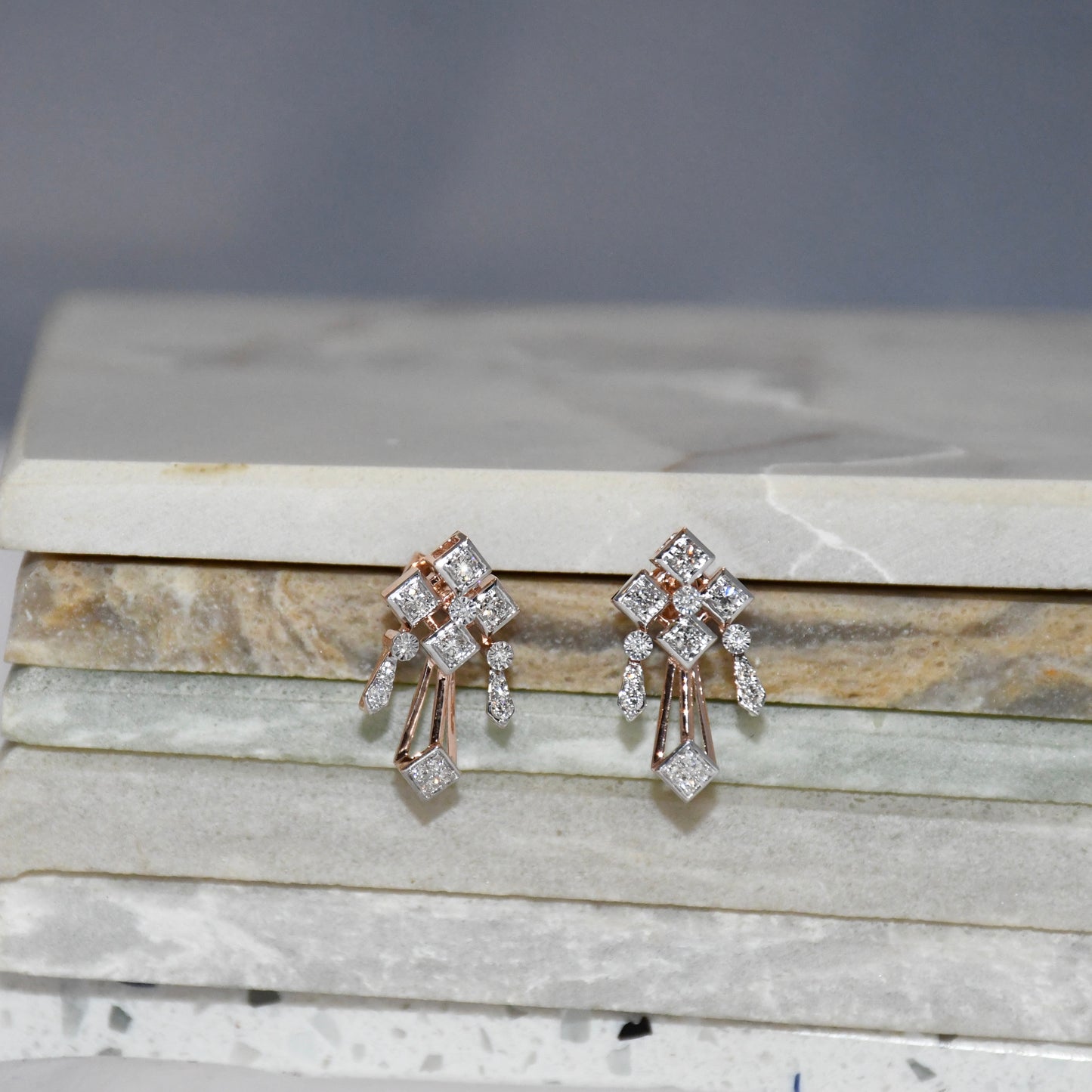 Pair of diamond earrings on a marble surface