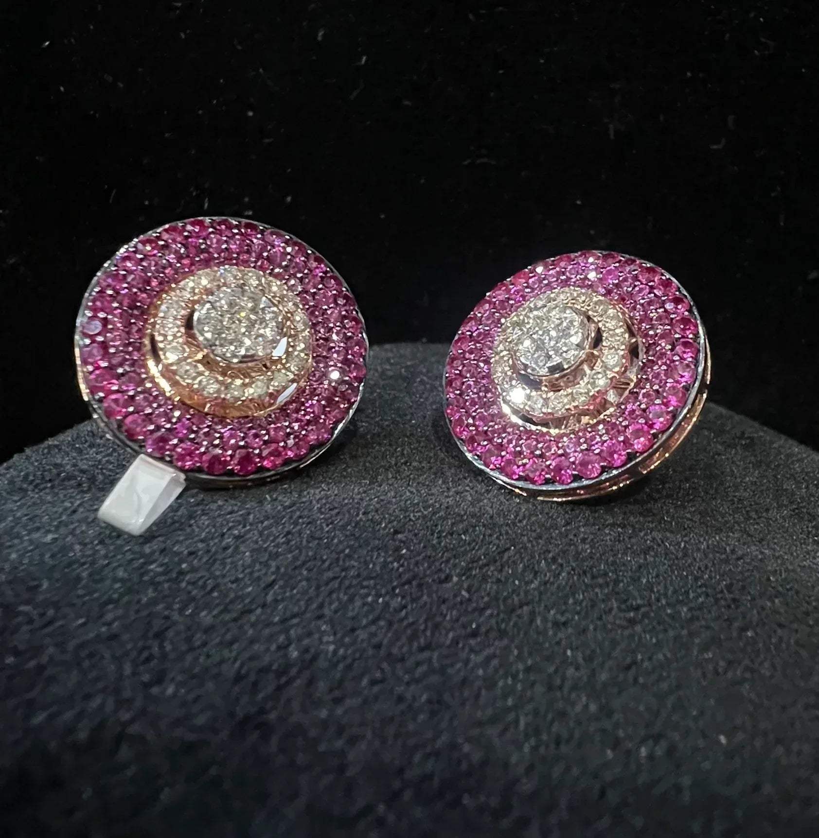 A pair of gold diamond stud earrings with a gold band on a black mannequin.