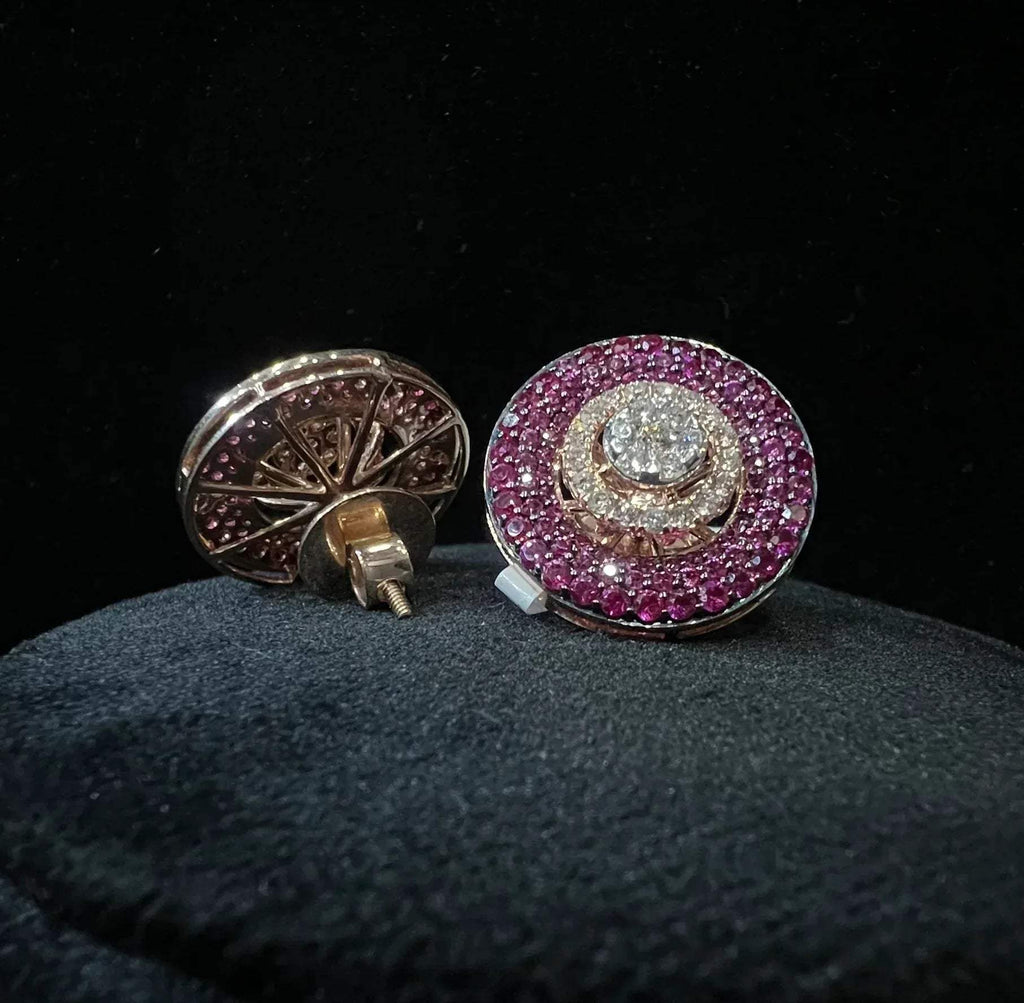 A pair of gold diamond stud earrings with a gold band on a black mannequin.