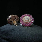 A pair of gold diamond stud earrings with a gold band on a black mannequin.