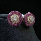 A pair of gold diamond stud earrings with a rose gold band on a black mannequin.