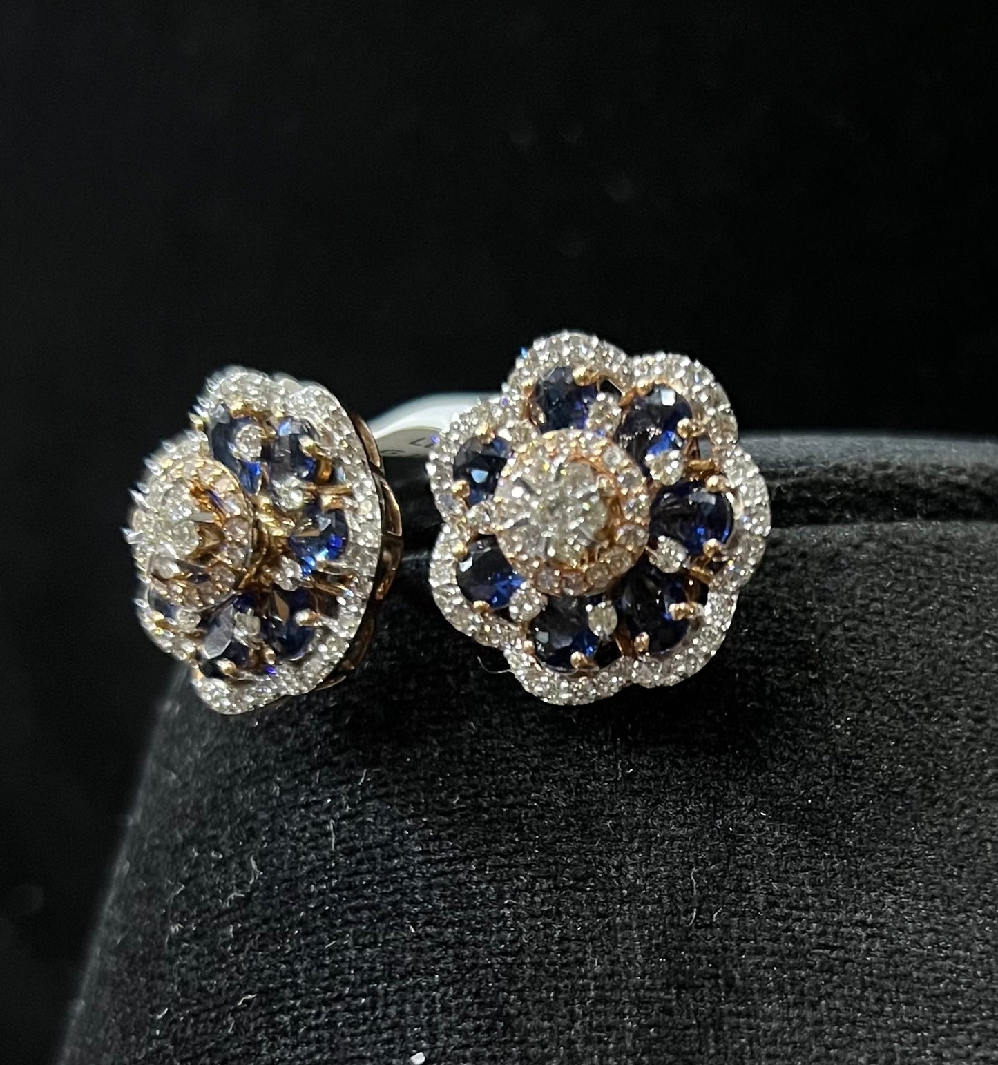 Close-up of natural blue stone and diamond earrings in a floral stud design, crafted in gold – elegant women’s diamond earrings.