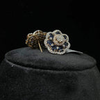 Close-up of natural blue stone and diamond earrings in a floral stud design, crafted in gold – elegant women’s diamond earrings.