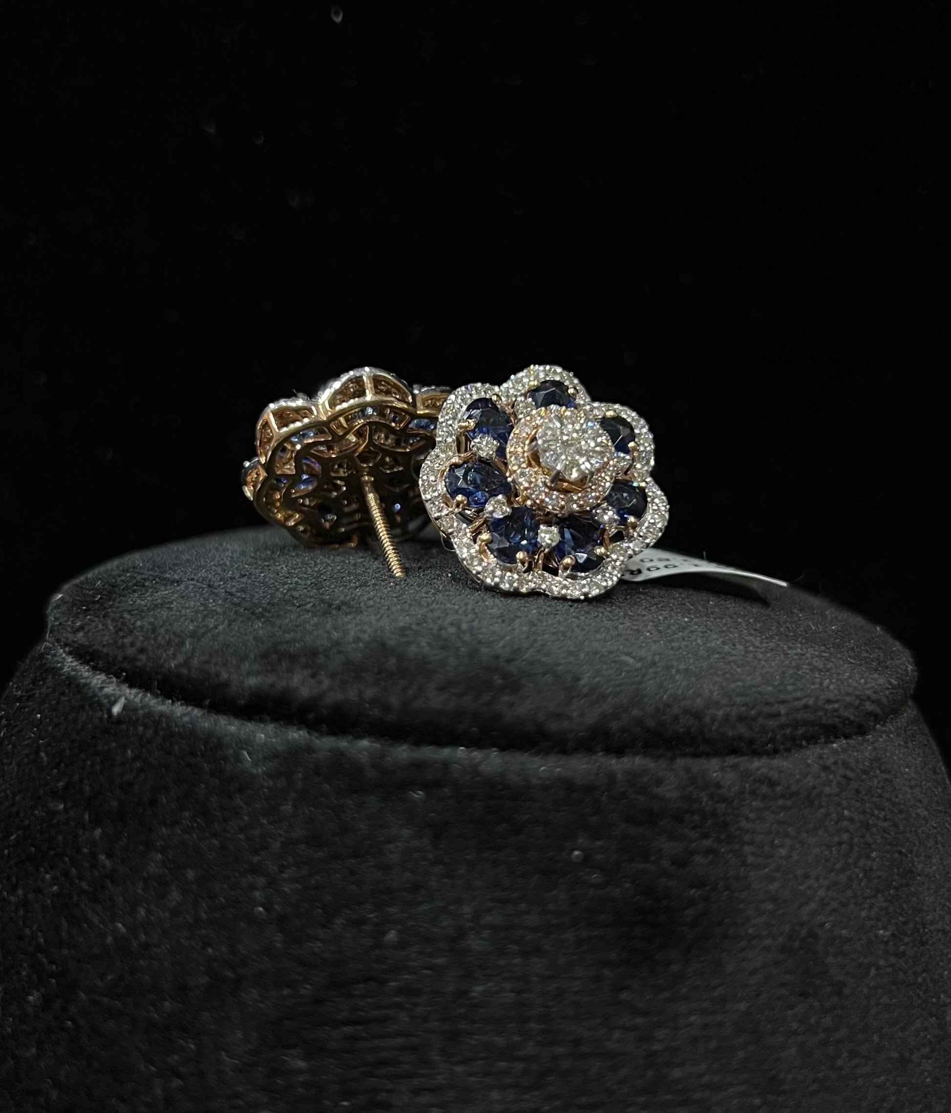 Close-up of natural blue stone and diamond earrings in a floral stud design, crafted in gold – elegant women’s diamond earrings.