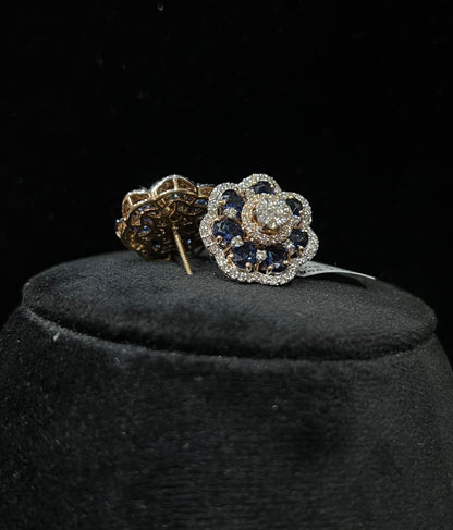 Close-up of natural blue stone and diamond earrings in a floral stud design, crafted in gold – elegant women’s diamond earrings.