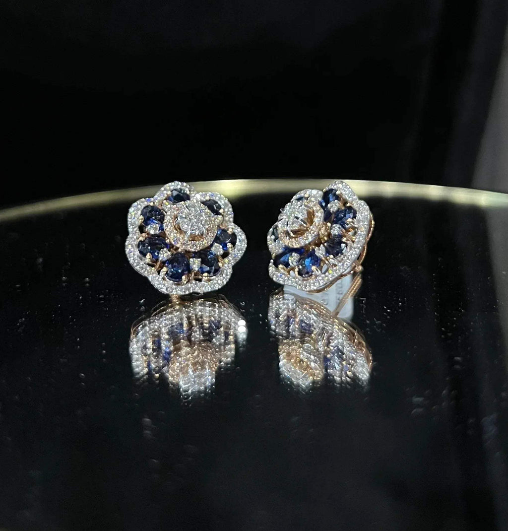 Close-up of natural blue stone and diamond earrings in a floral stud design, crafted in gold – elegant women’s diamond earrings.
