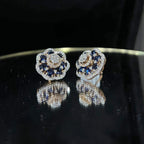 Close-up of natural blue stone and diamond earrings in a floral stud design, crafted in gold – elegant women’s diamond earrings.