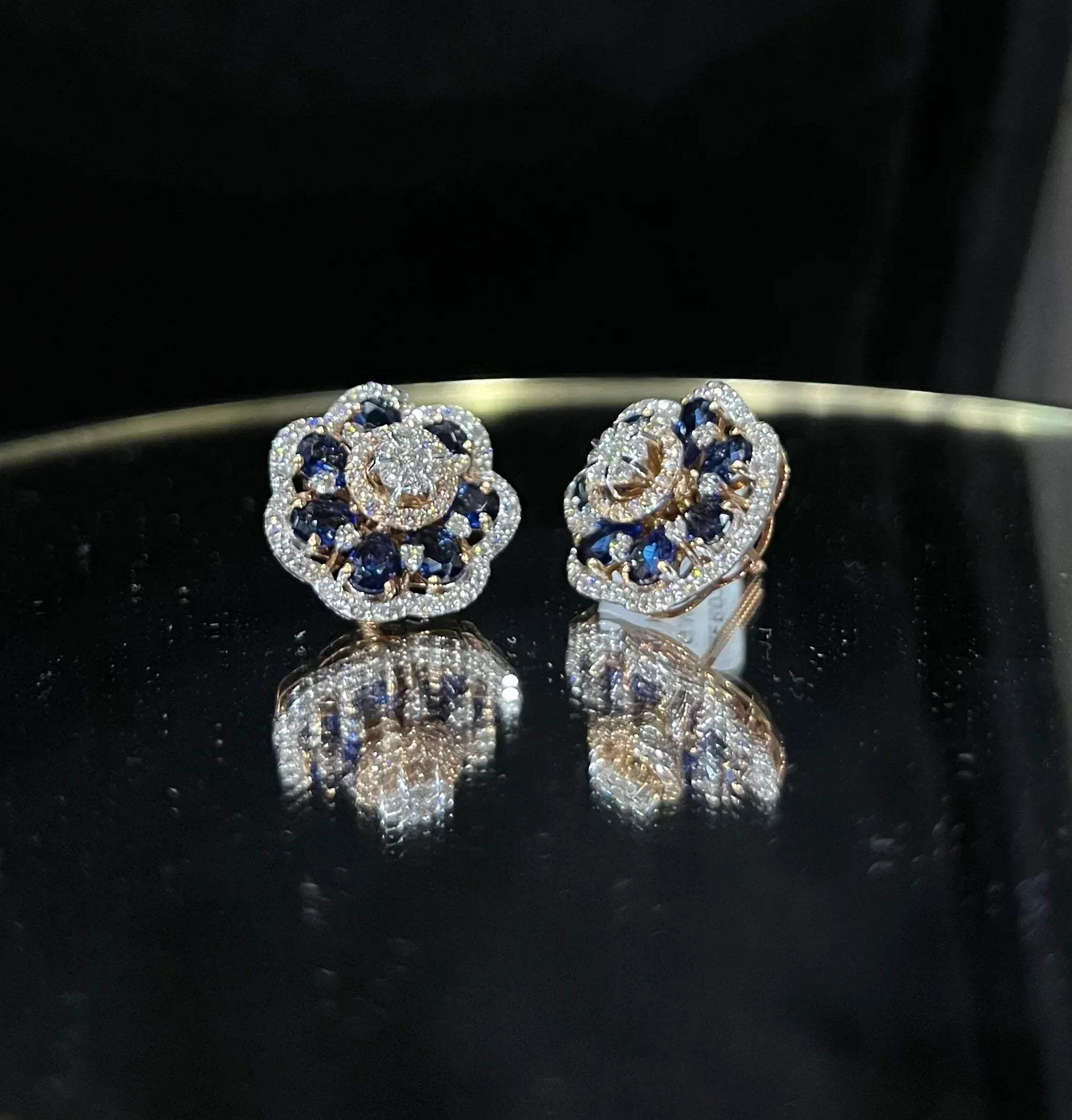 Close-up of natural blue stone and diamond earrings in a floral stud design, crafted in gold – elegant women’s diamond earrings.