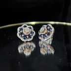Close-up of natural blue stone and diamond earrings in a floral stud design, crafted in gold – elegant women’s diamond earrings.