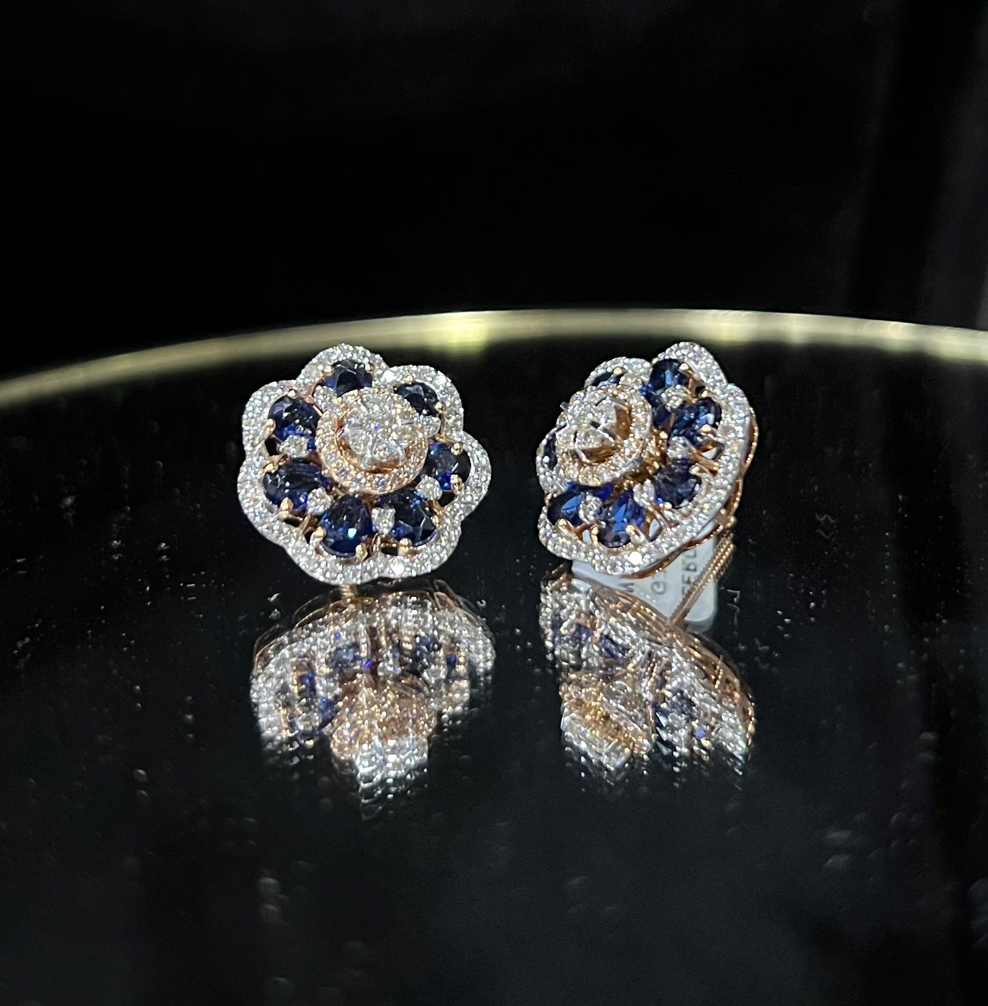 Close-up of natural blue stone and diamond earrings in a floral stud design, crafted in gold – elegant women’s diamond earrings.