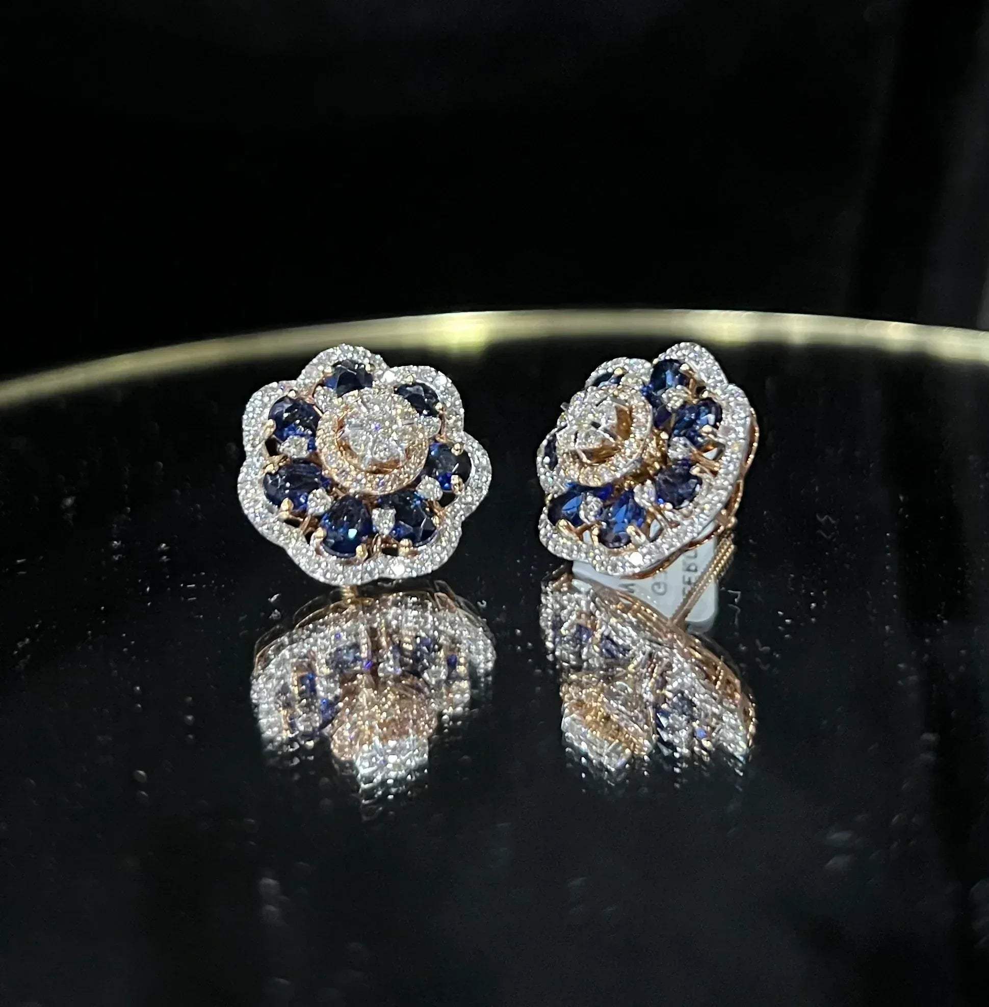 Close-up of natural blue stone and diamond earrings in a floral stud design, crafted in gold – elegant women’s diamond earrings.