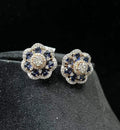 Close-up of natural blue stone and diamond earrings in a floral stud design, crafted in gold – elegant women’s diamond earrings.
