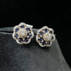 Close-up of natural blue stone and diamond earrings in a floral stud design, crafted in gold – elegant women’s diamond earrings.