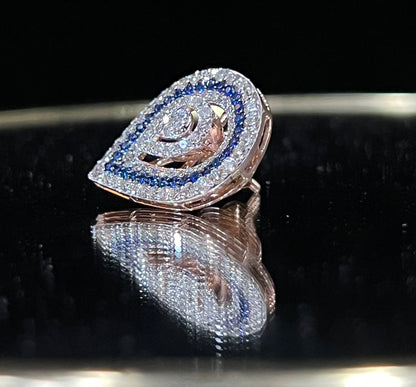 A pair of gold diamond earrings with a geometric pattern, displayed on a reflective surface.