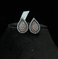 A pair of gold diamond earrings with a geometric pattern, displayed on a mannequin bust.