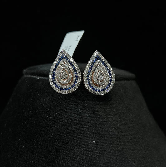 A pair of gold diamond earrings with a geometric pattern, displayed on a mannequin bust.