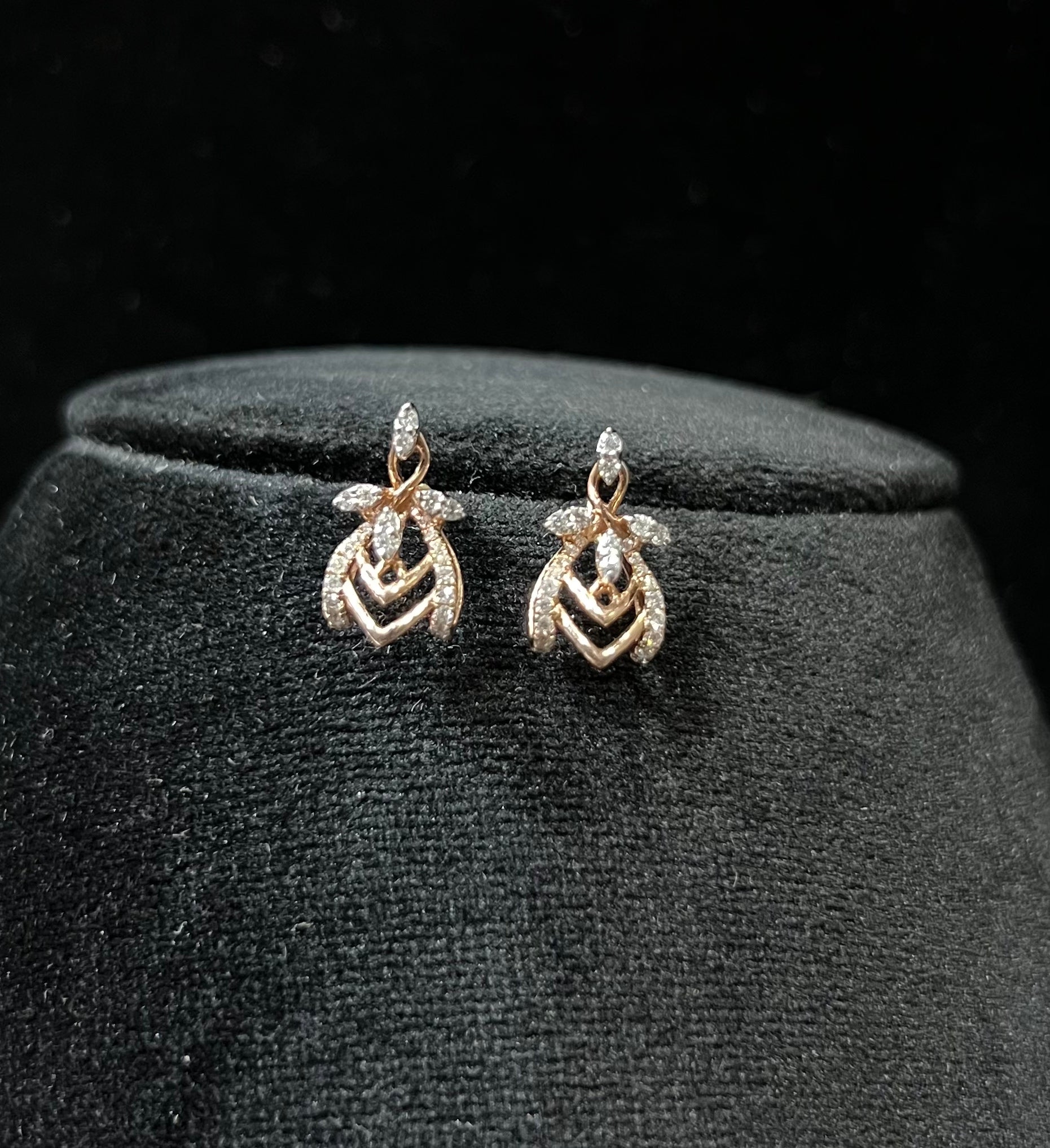A pair of diamond earrings with a rose gold or gold color finish, featuring a V-shaped design with diamond embellishments.