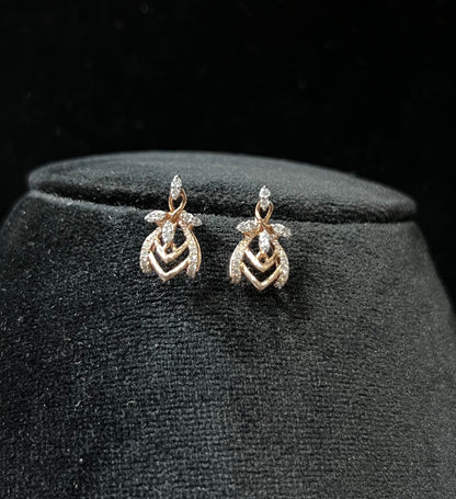 A pair of diamond earrings with a rose gold or gold color finish, featuring a V-shaped design with diamond embellishments.