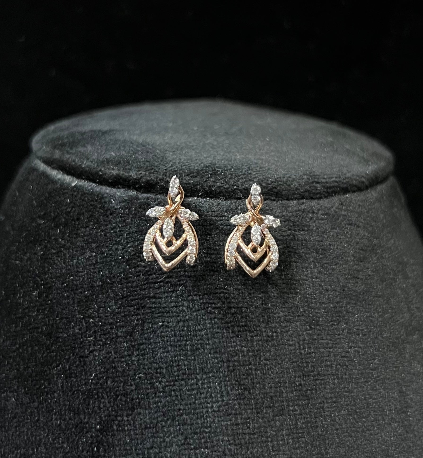 A pair of diamond earrings with a rose gold or gold color finish, featuring a V-shaped design with diamond embellishments.