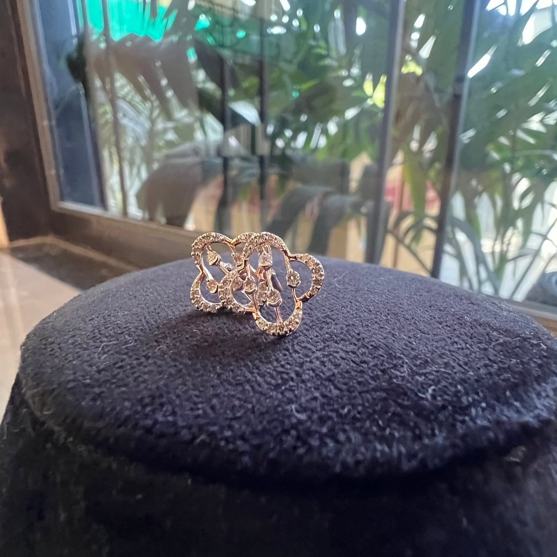 clover bloom diamond stud earrings in gold with openwork floral design and sparkling diamonds.